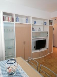 ein Wohnzimmer mit weißen Regalen und einem TV in der Unterkunft ChiarAlice/home: 10 min mare - 5 min centro in Chiavari