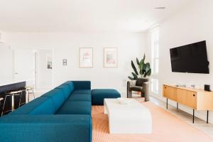 a living room with a blue couch and a tv at LoHi Clubhouse - Cityscape Panorama - Central LoHi in Denver
