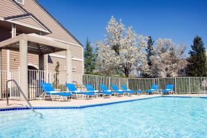 einen Pool mit blauen Liegestühlen und einem Pool in der Unterkunft Residence Inn San Ramon in San Ramon