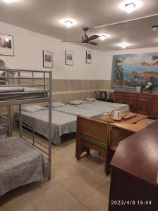 a room with three bunk beds and a table at Hostal Sant Jordi in Tossa de Mar