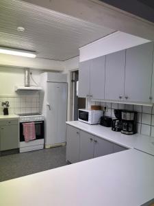 uma cozinha com armários brancos e um frigorífico branco em Traume vandrarhem em Visby