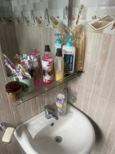 um lavatório de casa de banho com um espelho e uma prateleira por cima em Room in Guest room - Single Bedroom Sitting Room em Kampala