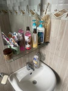 a bathroom sink with a mirror and a shelf above it at Room in Guest room - Single Bedroom Sitting Room in Kampala