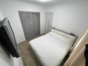 um pequeno quarto com uma cama e uma televisão em ROV em Suceava