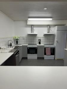 una gran cocina con electrodomésticos blancos en una habitación en Traume vandrarhem, en Visby