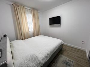 um pequeno quarto com uma cama e uma televisão de ecrã plano em ROV em Suceava