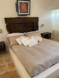 duże łóżko z białą pościelą i poduszkami w obiekcie trulli mancinella w mieście Locorotondo