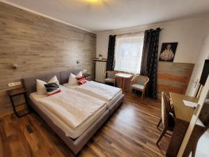 een slaapkamer met een bed en een tafel en stoelen bij Hotel MoinMoin in Bad Bramstedt