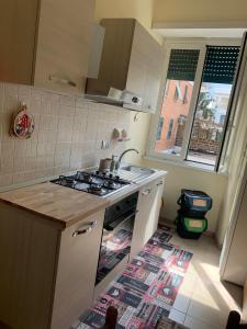 ローマにあるB&B da Giuliaのキッチン(コンロ、シンク付)、窓が備わります。