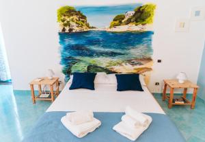 a bedroom with a bed with a painting of the ocean at Casetta Giulia in Procida