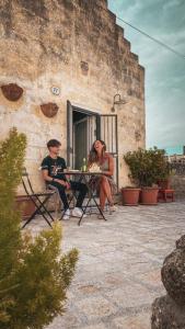 un hombre y una mujer sentados en una mesa en un patio en Il Geco en Matera