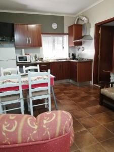 a kitchen with wooden cabinets and a table and chairs at Casa Vaz 2 in Grândola