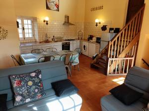 een keuken en een woonkamer met een bank en een tafel bij Gîte du Cladan in LʼÉpine