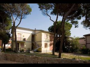 a white house with trees in front of it at Homely apartment close to the beach - Beahost in Rosolina Mare +12 photos