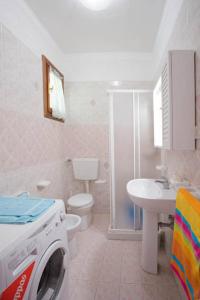 ein Badezimmer mit einer Waschmaschine und einem Waschbecken in der Unterkunft Homely apartment close to the beach - Beahost in Rosolina Mare