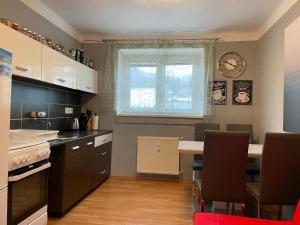 a kitchen with a table and a clock on the wall at Horský Apartment David in Vysoke Tatry - Horny Smokovec