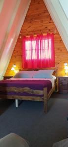 - une chambre avec un grand lit et une fenêtre rouge dans l'établissement Cabañas en Koslay, à Juana Koslay 