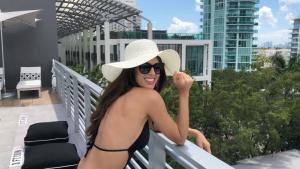 a woman in a bikini and a hat on a balcony at 6080 Design Hotel by Eskape Collection in Miami Beach