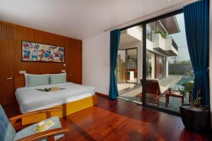 a bedroom with a bed and a large window at Hola Villa 2 by Ovui in Hiếu Nhơn