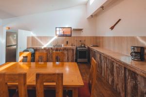a kitchen with a wooden counter and a wooden table at Peumayen Atacama cabaña&Hostal in San Pedro de Atacama