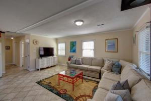 a living room with a couch and a coffee table at Beach Bliss in Kill Devil Hills