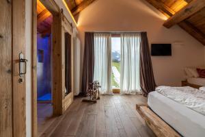 1 dormitorio con cama y ventana grande en Casera Cornolera en Chies dʼAlpago