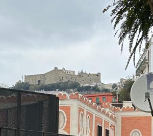 a large castle on a hill behind a building at MH Design Hotel in Naples