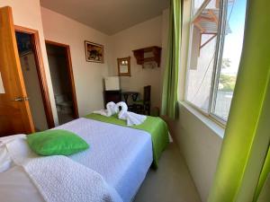 two beds in a room with a window at El Rincón de George in Puerto Villamil