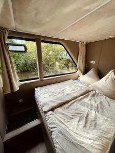 a bed in the back of a camper with a window at KL Moselboote - Hausboot Niara in Bernkastel-Kues