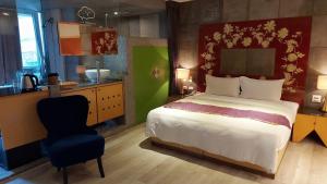 a bedroom with a large bed and a kitchen at Jungle City Motel in Chiayi City