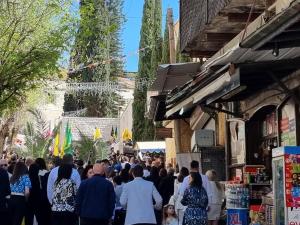 a crowd of people walking down a street at La Casetta in Nazareth