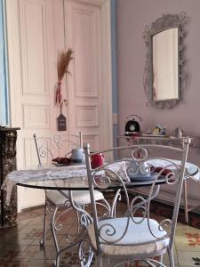 FlorensacにあるChez Dédou et Madouのダイニングルーム(ガラスのテーブル、椅子付)