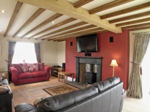 a living room with a couch and a fireplace at Wandale Barn in Slingsby