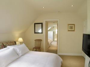 a bedroom with a white bed and a television at Wandale Barn in Slingsby