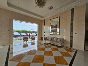 ein Wohnzimmer mit Couch und Schachbrettboden in der Unterkunft Apartement Sky House BSD TL19D By LiviRooms in Tjilandak