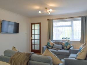 sala de estar con 2 sofás y TV de pantalla plana en Rest-a-while en Freshwater