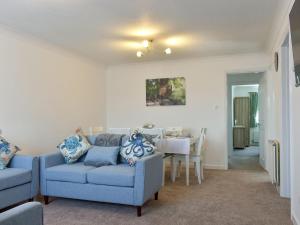 sala de estar con 2 sillas azules y mesa en Rest-a-while en Freshwater