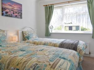 2 camas en un dormitorio con ventana en Rest-a-while en Freshwater