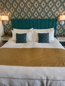 a bedroom with a large bed with a green headboard at The Gatsby Blackpool - Formerly The Windsor in Blackpool