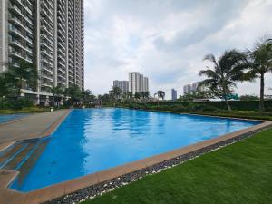 a large blue swimming pool in a city with tall buildings at Apartement Sky House BSD By LiviRooms in Tjilandak