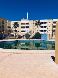 a swimming pool in front of a building at Piso luminoso cerca de la playa in Roquetas de Mar