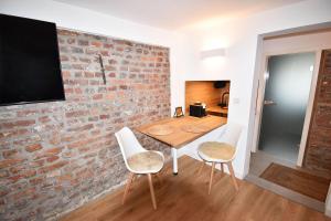 a dining room with a brick wall and a table and chairs at SWEET HOME in Meerbusch bei Messe Düsseldorf in Meerbusch