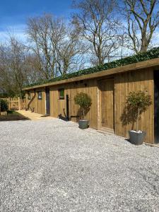 a building with two potted trees in front of it at Newly renovated Stables conversion in Burstwick