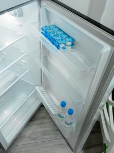 een open koelkast met flessen water erin bij Comfortable Apartment Unirii Square - CAL3B in Boekarest