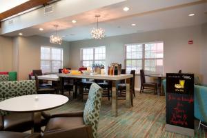 a dining room with tables and chairs and windows at Residence Inn Kansas City Olathe in Olathe
