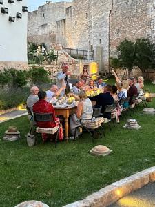 a group of people sitting around a table in front of a castle at Paragon 700 Boutique Hotel & SPA in Ostuni