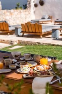 a table with plates of food and cups of orange juice at Paragon 700 Boutique Hotel & SPA in Ostuni