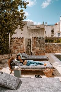 a woman laying on a couch on a patio at Paragon 700 Boutique Hotel & SPA in Ostuni