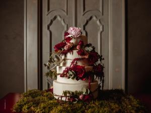 a three tiered wedding cake with flowers on a table at Paragon 700 Boutique Hotel & SPA in Ostuni