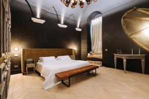 a bedroom with a bed and a mirror and a bench at Paragon 700 Boutique Hotel & SPA in Ostuni